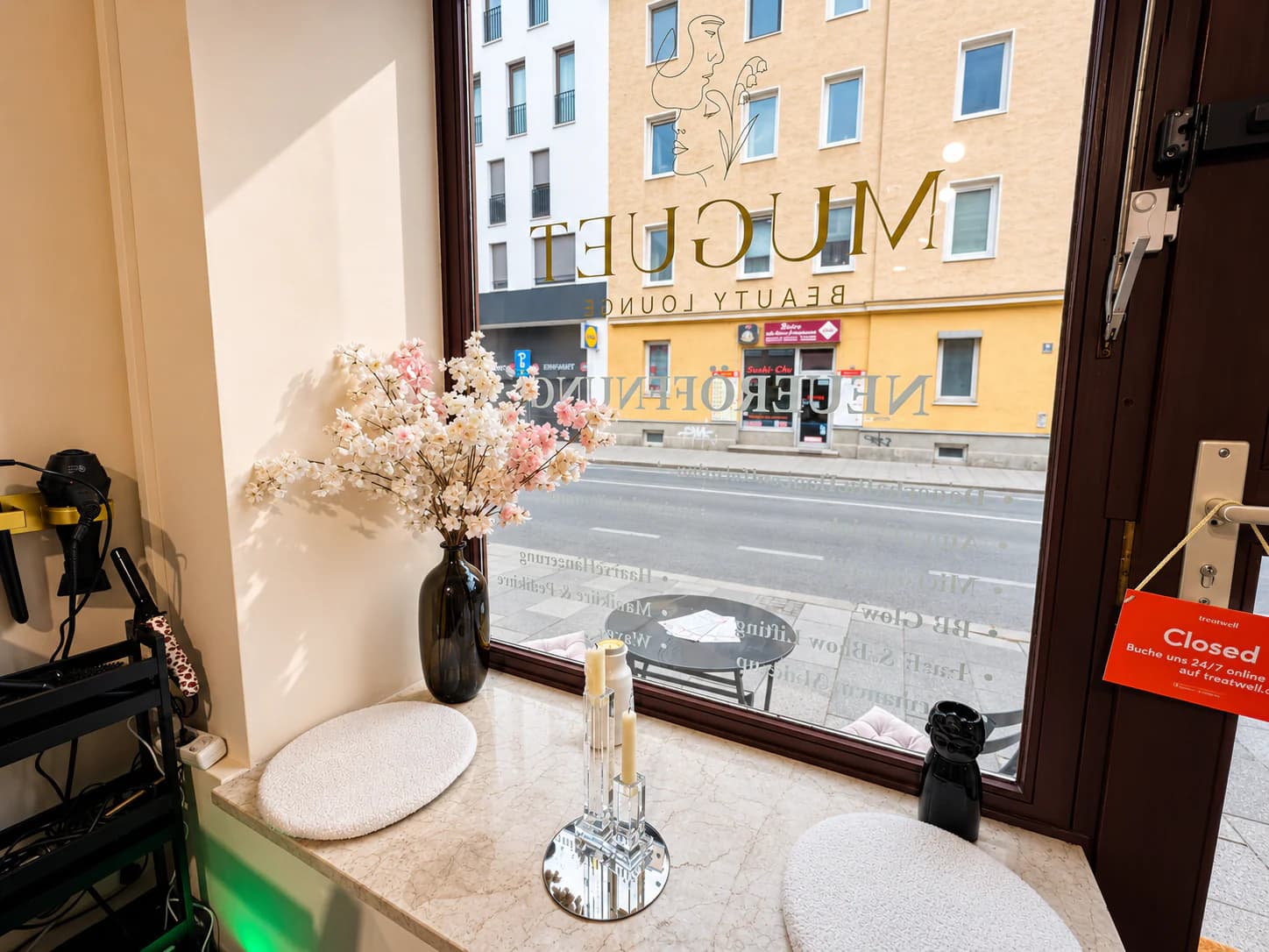 Fensterplatz mit Blumen und Schriftzug auf der Scheibe
